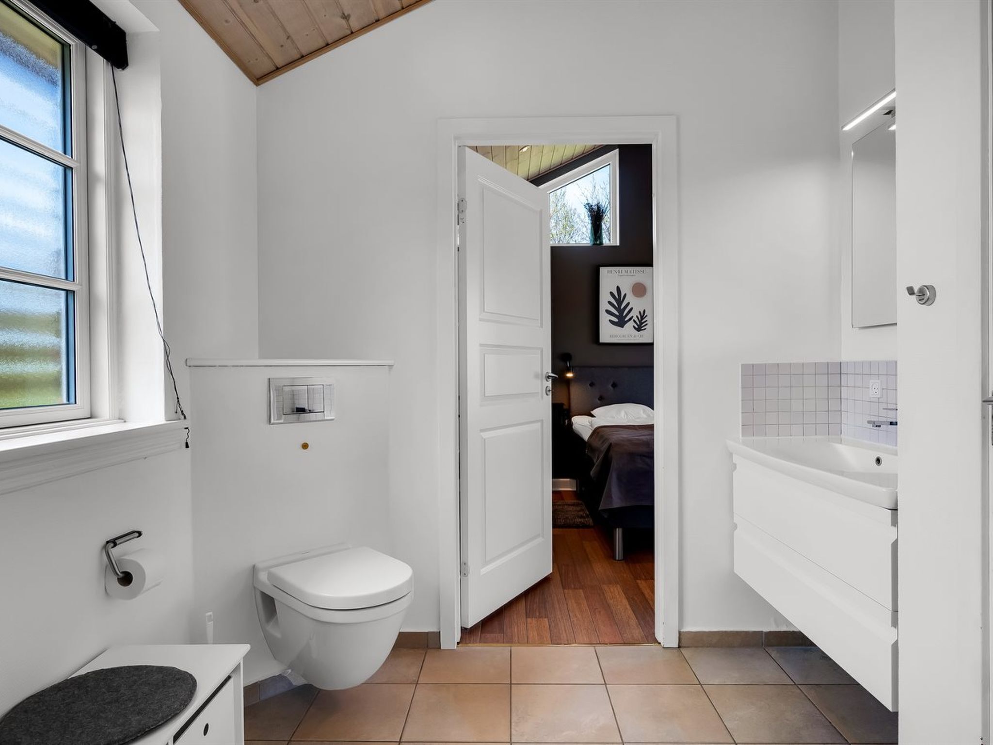 Une salle de bain moderne équipée de toilettes, d’un lavabo et d’une zone douche.