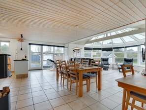 Relax in this inviting room with a dining table, sofa, and armchair, plus a fireplace and large window with a view.