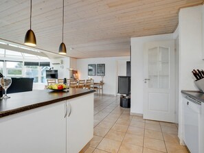 Enjoy meals in the kitchen with a central island and dining area, featuring a TV and comfortable seating.