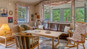 A cozy room with a wooden ceiling, a sofa, a dining table, and a rocking chair. - "Tala" - 4km from the sea by Interhome (Blåvand)