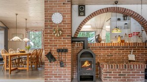 A cozy interior with a brick fireplace, wooden dining table, and chairs. - "Tala" - 4km from the sea by Interhome (Blåvand)