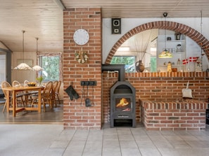 A cozy interior with a brick fireplace, wooden dining table, and chairs.
