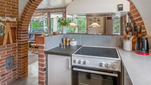 A kitchen with a gas stove, oven, and a brick wall. - "Tala" - 4km from the sea by Interhome (Blåvand)