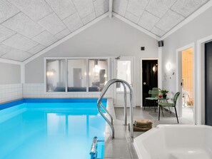A swimming pool with a clear blue water, a white bathtub, and a door leading to another room. - "Femmy" - 600m from the sea by Interhome (Blåvand)