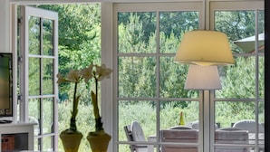 A room with a large window, a lamp, and a view of greenery outside. - "Raili" - 1.5km from the sea by Interhome (Blåvand)