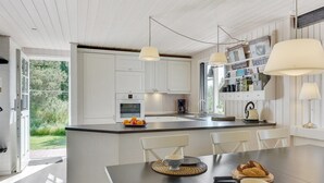 A modern kitchen with white cabinetry, a large island, and pendant lighting. - "Raili" - 1.5km from the sea by Interhome (Blåvand)