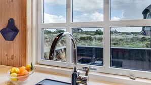 Una cocina con vista a un campo verde y una casa.