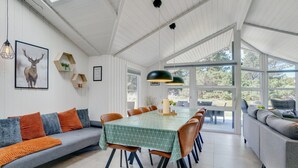 A spacious dining area with a long table, surrounded by chairs, and a large window offering a view of the outdoors. - "Edeltraut" - 900m from the sea by Interhome (Blåvand)