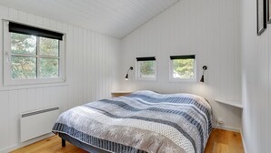 A bedroom with a large bed, two bedside tables, a radiator, and three windows with blinds. - "Edeltraut" - 900m from the sea by Interhome (Blåvand)