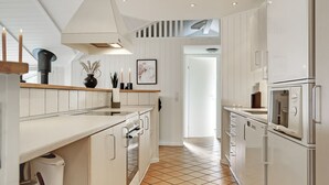 A modern kitchen with white cabinetry, a tiled floor, and a central island. - "Stense" - 900m from the sea by Interhome (Blåvand)