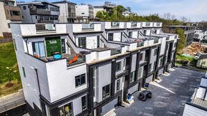 Een modern meerlaags woongebouw met balkons, grote ramen en een plat dak.