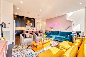 A modern living room with a blue sofa, a coffee table, and a patterned rug.