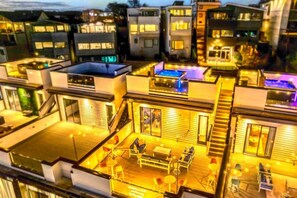 Un immeuble résidentiel moderne à plusieurs étages, doté de balcons et d’espaces extérieurs aménagés pour se détendre.