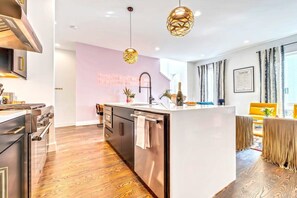 A modern kitchen with a central island, stainless steel appliances, and pendant lighting.