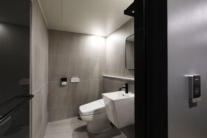A modern bathroom with a toilet, a sink, and a shower area. - HOTEL THE ONE (Gangneung)