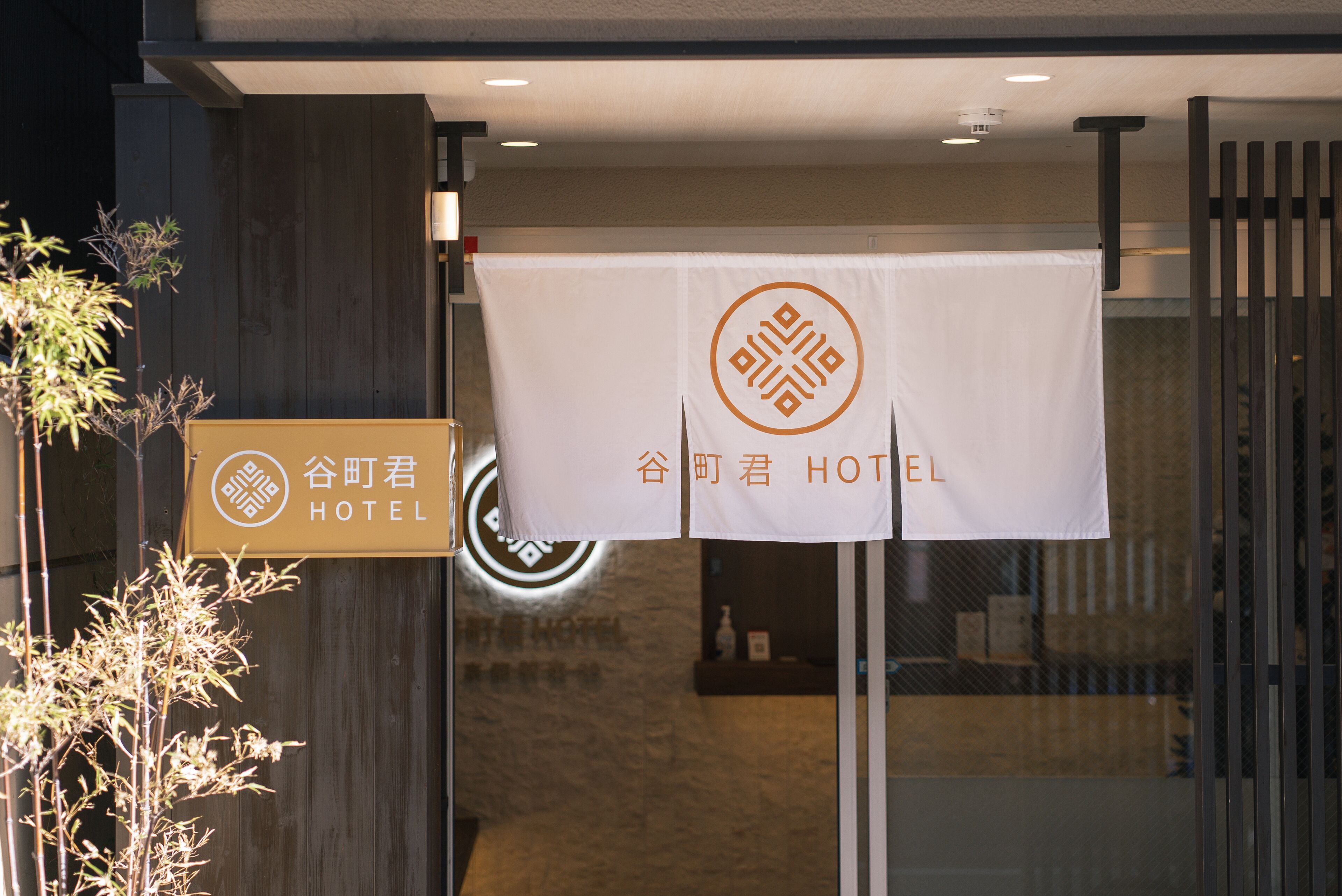 A hotel entrance with a sign reading "谷町君 HOTEL".