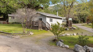A small, single-story cabin with a wooden deck and stairs leading to a front door. - The General Grant Cabin Near Sequoia w Pool (Three Rivers)