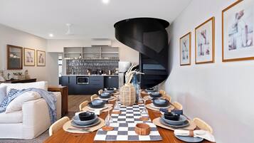 A dining area with a checkered tablecloth, black and white plates, and a central vase.