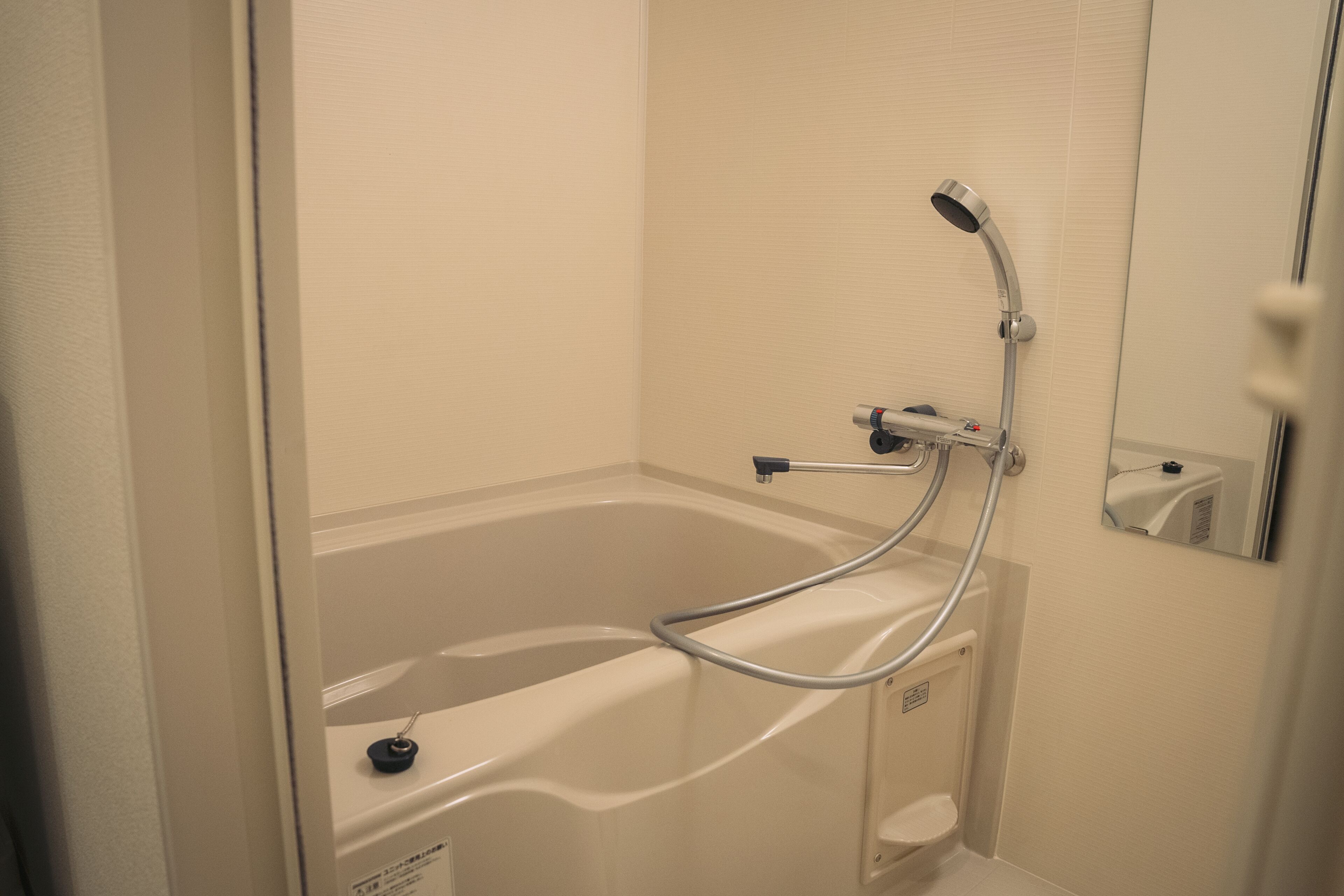 Un baño moderno con bañera, cabezal de ducha manual e inodoro.