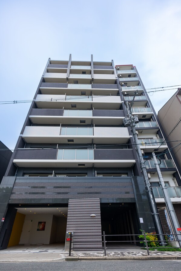 A multi-story building with a modern design, featuring balconies on each floor and a large entrance with a metal gate. - Tanimachikun Star Hotel Ebisunishi 48 (Osaka)