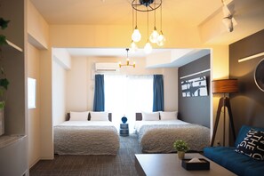 A hotel room with two beds, a sofa, a lamp, and a ceiling light fixture. - Tanimachikun Star Hotel Ebisunishi 48 (Osaka)