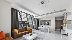 A modern living room with a sofa, coffee table, and large windows.