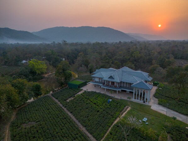 A large estate with a main building, expansive gardens, and a view of the surrounding landscape.