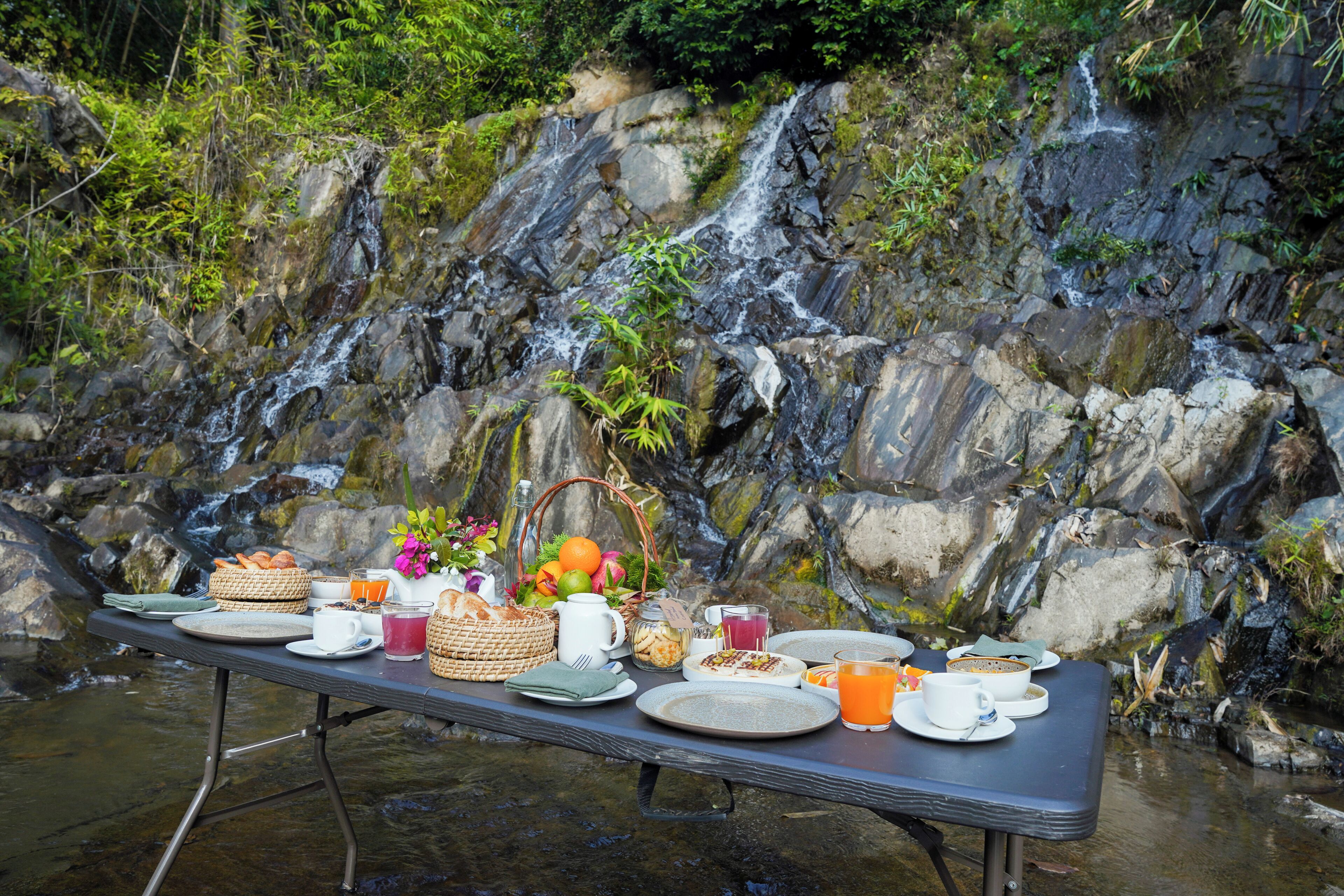 Un montaje para picnic con una mesa cerca de una cascada.