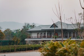 A large, two-story building with a balcony and arched windows.