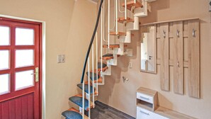 A staircase with a unique design, a red door, and a wooden wardrobe. - 2 bedroom cozy home in Eggesin (Eggesin)