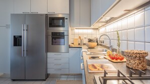 Eine moderne Küche mit Edelstahlgeräten, einem Holztisch mit Gemüse und einem gewebten Korb.
