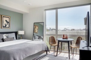 Relax in a spacious room with a large bed, bedside table, and city views.