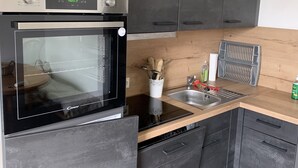 Une cuisine moderne dotée d’un four encastré, d’un évier et de plans de travail en bois.