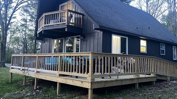 A two-story house with a wooden deck and a balcony. - Peaceful and secluded getaway in Saline County  (Benton)