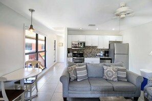 A modern kitchen with white cabinets, a built-in oven, and a refrigerator.