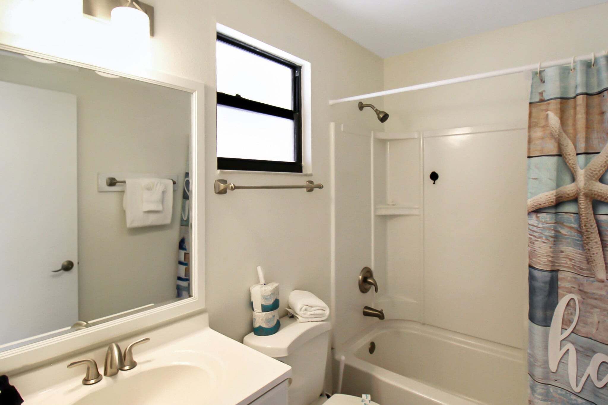 Un bagno con lavandino, specchio, toilette e vasca da bagno.