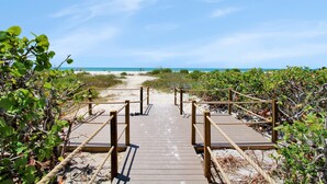 A wooden boardwalk leading to a beach with clear skies. - Pet friendly paradise on Sanibel Island with private beach - Signal Inn 12 (Sanibel)