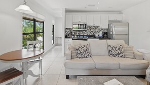 A modern kitchen with white cabinets, a refrigerator, and a microwave. - Pet friendly paradise on Sanibel Island with private beach - Signal Inn 12 (Sanibel)