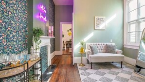 Ein gemütliches Wohnzimmer mit Kamin, einem weißen Sofa und einem gemusterten Teppich.