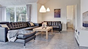 A modern living room with a black leather sofa, a wooden coffee table, and pendant lighting. - "Sada" - 12km from the sea by Interhome (Oksbøl)