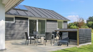 A modern house with a patio area featuring a table and chairs, a barbecue grill, and a covered seating area. - "Sada" - 12km from the sea by Interhome (Oksbøl)