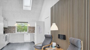 A modern kitchen with grey cabinets, a window, and a wooden dining table with two chairs. - "Sada" - 12km from the sea by Interhome (Oksbøl)