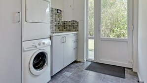 A compact laundry room with a washing machine, dryer, and a small countertop with a sink. - "Talida" - 12km from the sea by Interhome (Oksbøl)