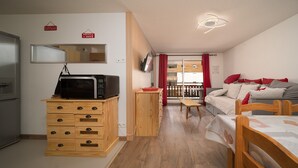 A compact living space with a kitchenette, a dining area, and a sofa. - Nice apt near the slopes 7 people (Allos)