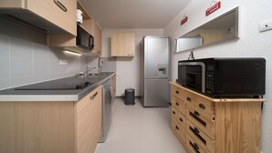 A compact kitchen with a microwave, refrigerator, and wooden cabinetry. - Nice apt near the slopes 7 people (Allos)