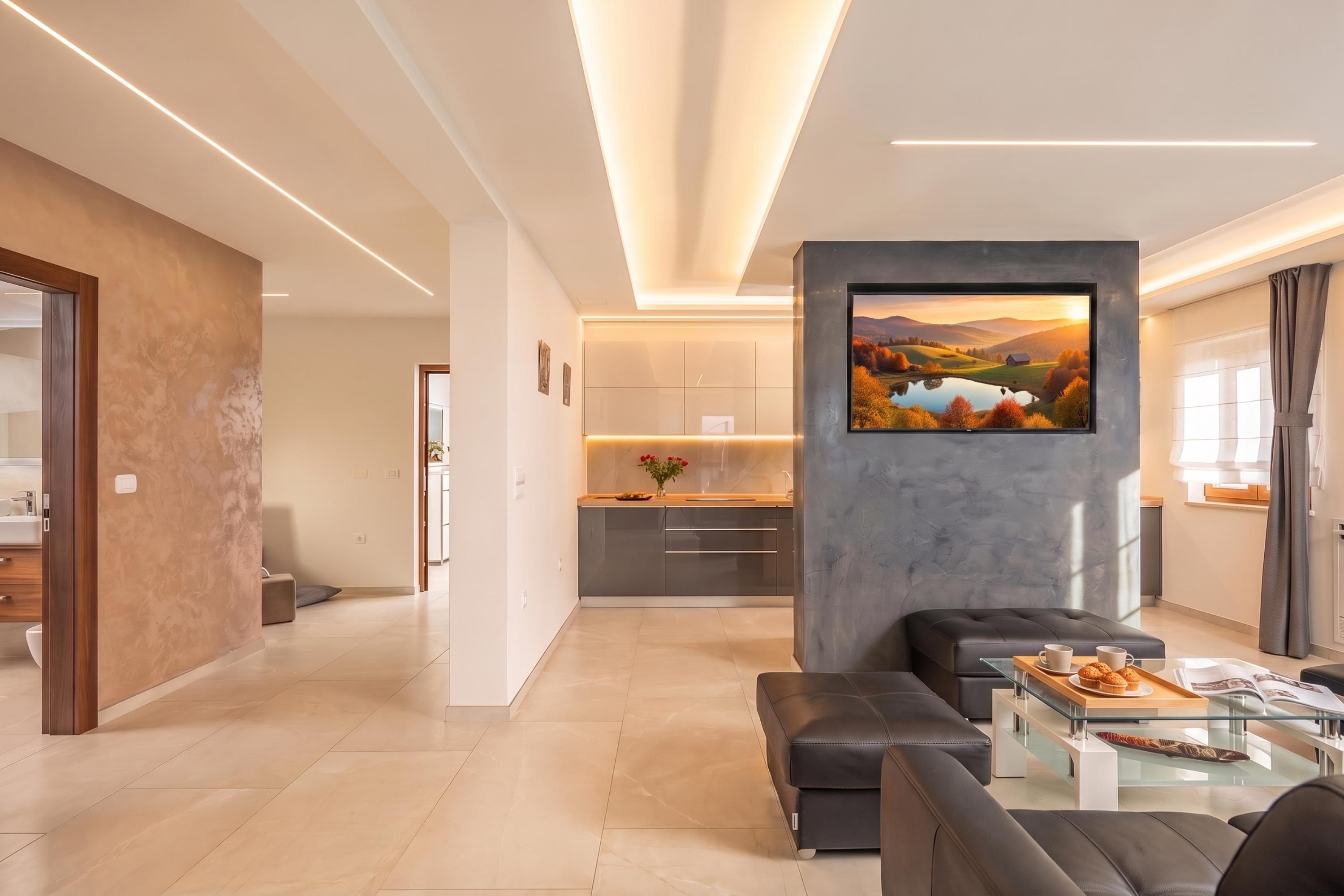 A modern living room with a sofa, a coffee table, and a TV mounted on a grey wall.