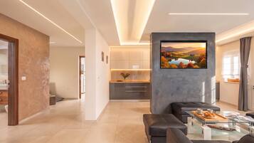 A modern living room with a sofa, a coffee table, and a TV mounted on a grey wall.