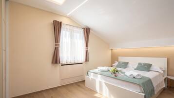 A modern bedroom with a bed, a bedside table, a nightstand, a window with curtains, and a ceiling light.