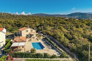 A villa with a swimming pool, surrounded by lush greenery and hills. - Villa Vilani Spa & Pool (Bakar)