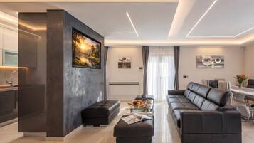 A modern living room with a sofa, ottoman, and a coffee table with a magazine.